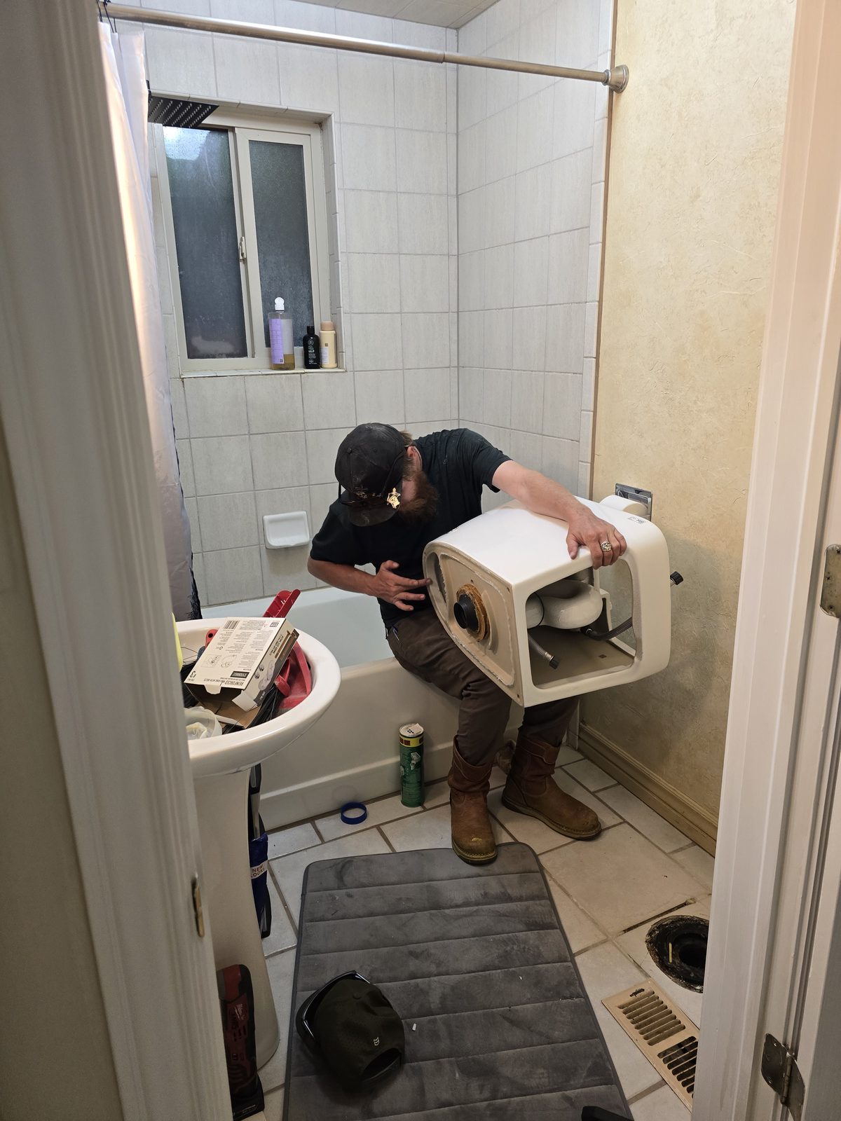 Kamas Valley Handyman removing an old toilet during a bathroom toilet swap