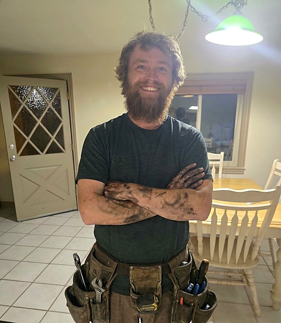 Kamas Valley Handyman owner smiling with arms crossed, wearing a full tool belt